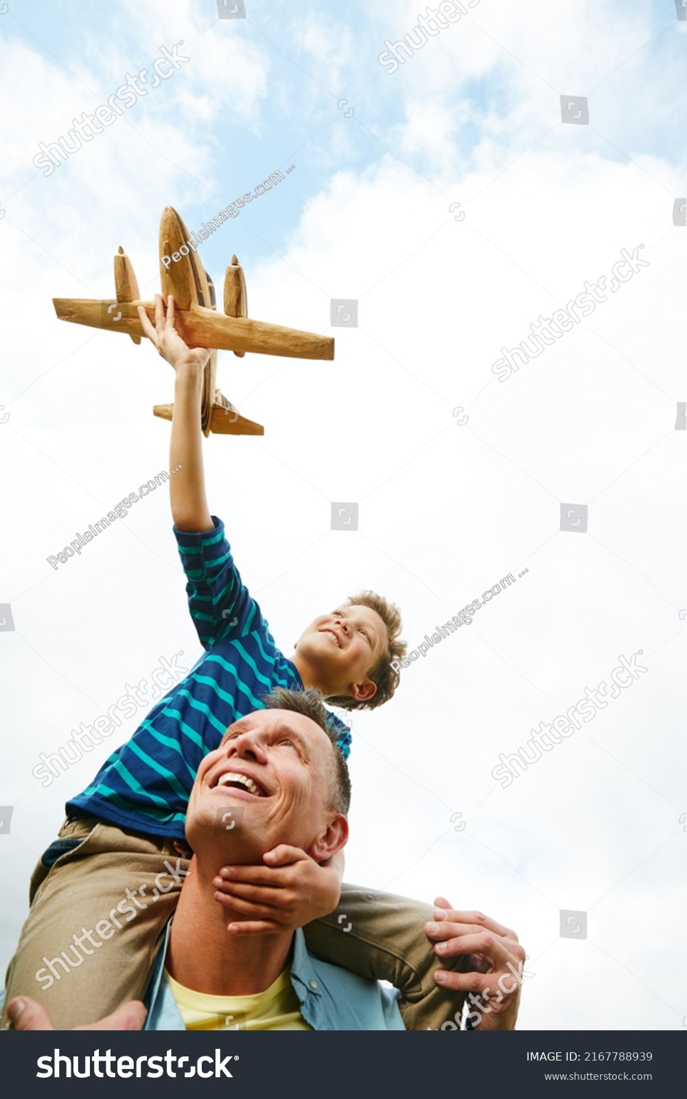 stock-photo-giving-flight-to-his-sons-imagination-shot-of-a-boy-playing-with-a-toy-airplane-while-getting-a-2167788939